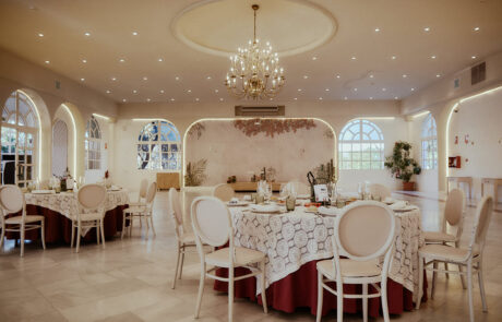 Montaje de mesas para banquete de boda con detalles florales y luces cálidas