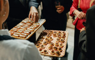 Personal de catering sirviendo aperitivos a los invitados durante el cóctel