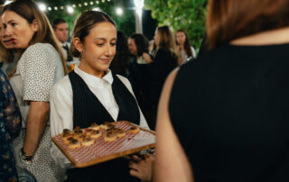 Personal de catering sirviendo aperitivos a los invitados durante el cóctel