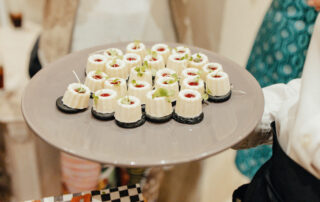 Personal de catering sirviendo aperitivos a los invitados durante el cóctel