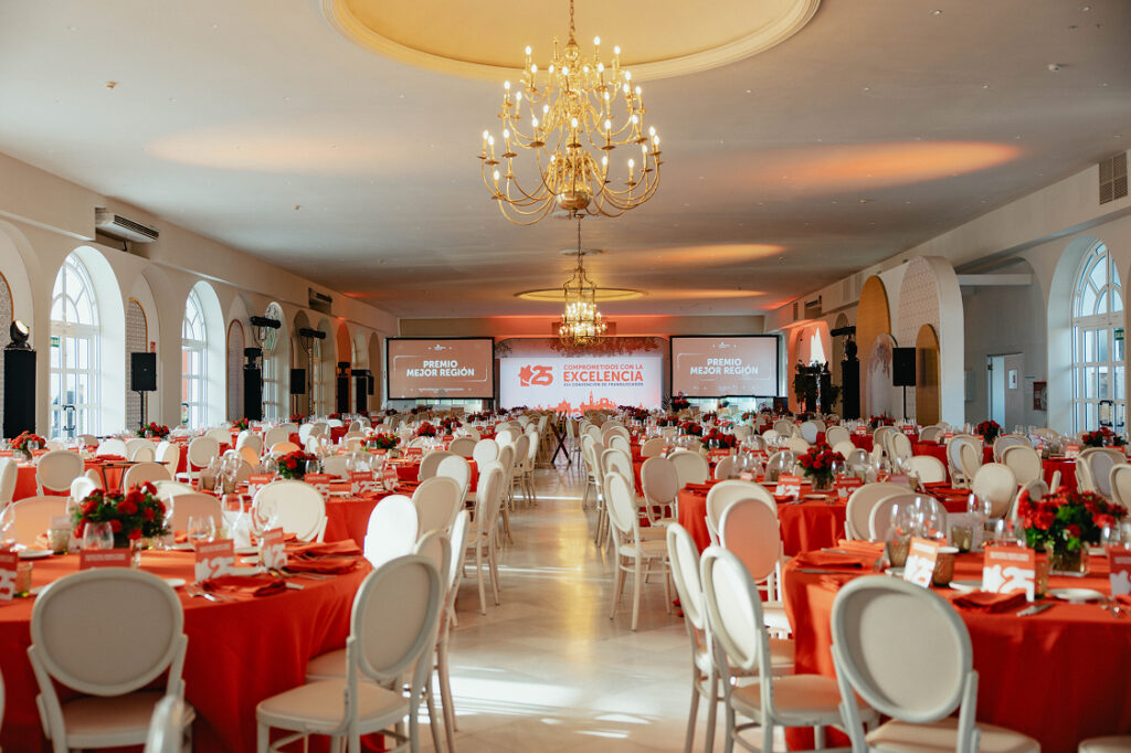 Salón preparado para evento corporativo con mesas y equipamiento en Hacienda Azahares.