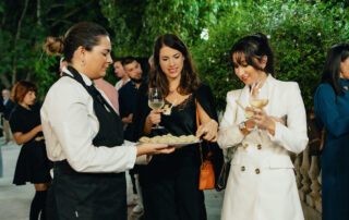 Personal de catering sirviendo aperitivos a los invitados durante el cóctel