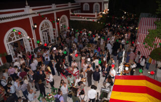 Montaje de cóctel al aire libre con mesas altas en jardín de hacienda