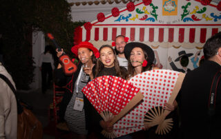 Montaje de cóctel al aire libre con mesas altas en jardín de hacienda azahares temática feria de abril