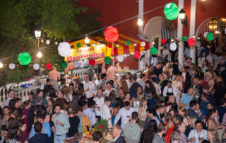 Montaje de cóctel al aire libre con mesas altas en jardín de hacienda