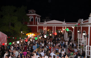 Montaje de cóctel al aire libre con mesas altas en jardín de hacienda