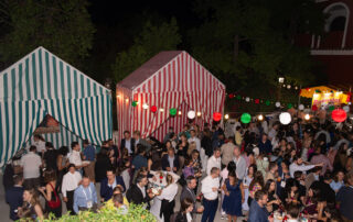 Montaje de cóctel al aire libre con mesas altas en jardín de hacienda azahares temática feria de abril