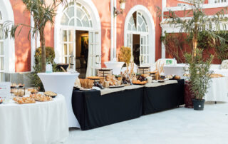 Montaje de mesa de aperitivos para cóctel en jardín de hacienda de eventos en Sevilla