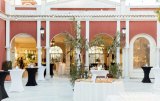 Montaje de mesa de aperitivos para cóctel en jardín de hacienda de eventos en Sevilla