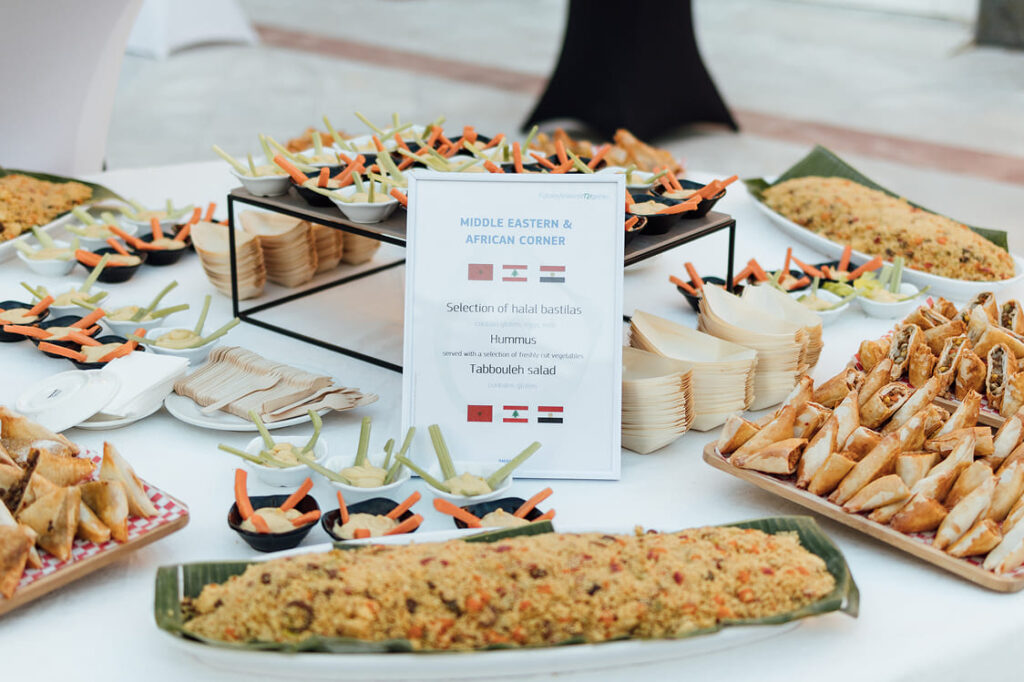 Montaje de mesa de aperitivos para cóctel en jardín de hacienda de eventos en Sevilla